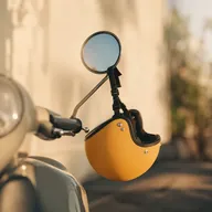 A honey-yellow delivery helmet hanging from a scooter mirror in morning light